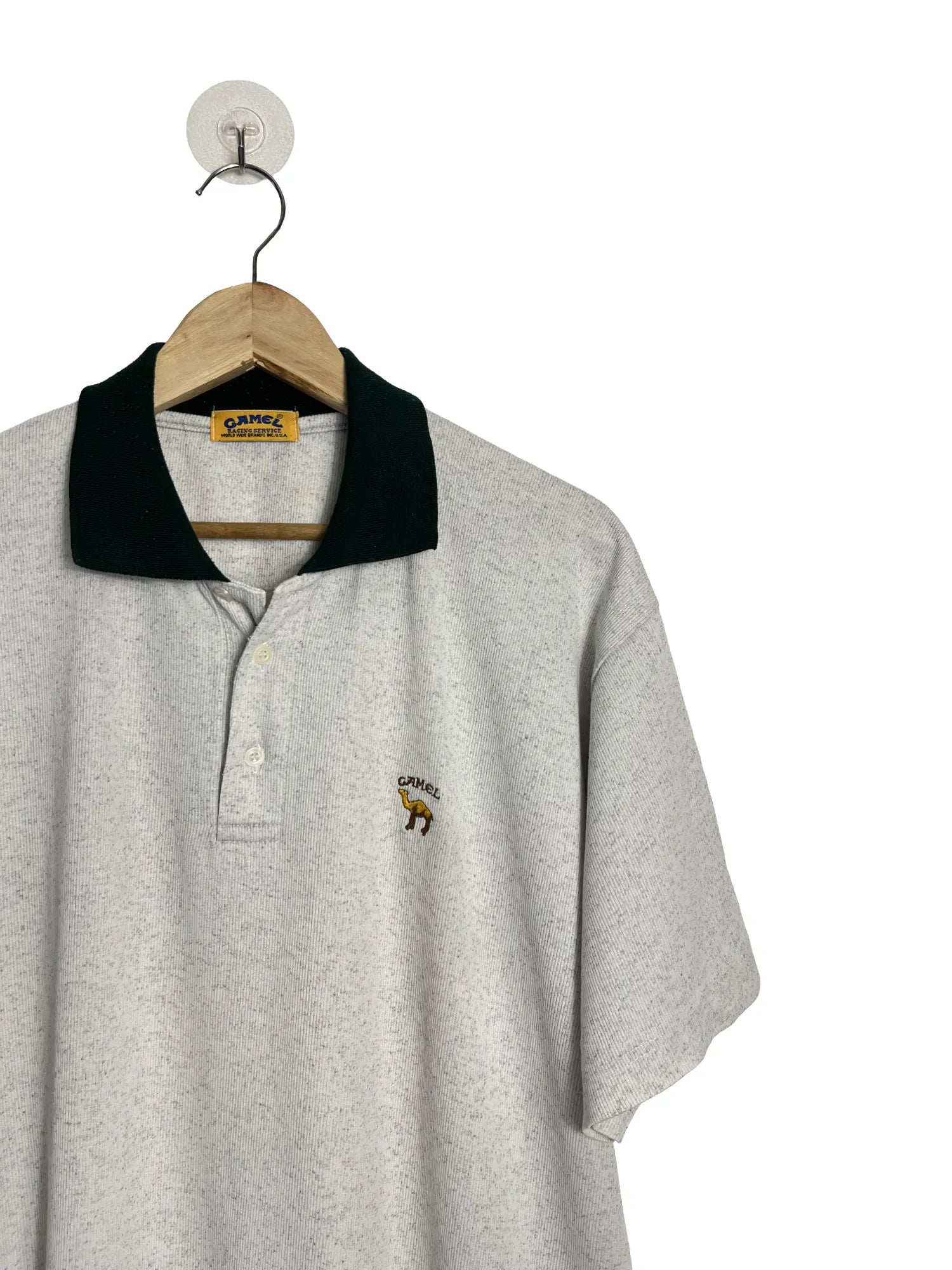 Détail logo Camel brodé au cœur sur polo homme blanc chiné col vert taille L